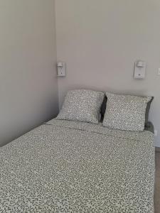 a bed with two pillows on it in a bedroom at Studios Saint Mau 1 in Saint-Maurice-de-Gourdans