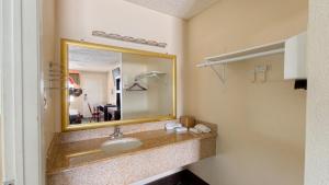 a bathroom with a sink and a mirror at Deluxe Inn By Capital O Odessa I-20 in Odessa +17 photos