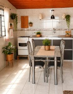 a kitchen with a table and chairs in a kitchen at Puxadinho do Sossego in Presidente Epitácio