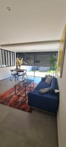 a living room with a blue couch and a table at Les chambres de Dolce in Bandol