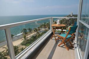 a balcony with a table and chairs and the ocean at PL BEACH FRONT APARTMENT in Bopitiya