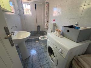 a bathroom with a washing machine and a sink at Chrisa's Apartments 1 in Missolonghi