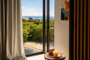 a room with a window with a bowl of fruit on a table at Villa Lunga Novalja in Novalja