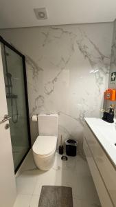 a white bathroom with a toilet and a shower at Apartamento de Real in Braga +7 photos