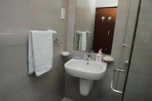 a white bathroom with a sink and a mirror at PL BEACH FRONT APARTMENT in Bopitiya +26 photos