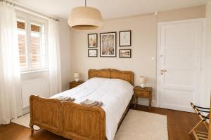 a bedroom with a wooden bed with white sheets at Gite à la campagne 4 étoiles - 200m2 in Sailly