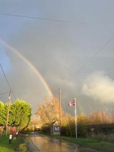 a rainbow in the sky over a street at Brookfield in Malmesbury +1 photo