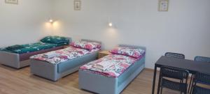 three beds in a room with a table and chairs at Wygodny duży pokój in Żarki