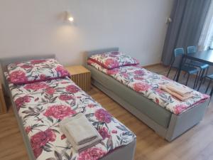 two beds in a room with a table and chairs at Wygodny duży pokój in Żarki
