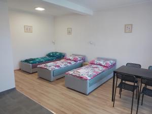 three beds in a room with a table and chairs at Wygodny duży pokój in Żarki