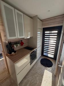 a small kitchen with white cabinets and a window at Pakarklių sodyba in Anykščiai +43 photos