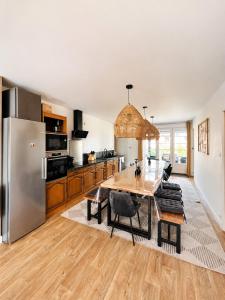a kitchen with a wooden table and a stainless steel refrigerator at Gite à la campagne 4 étoiles - 200m2 in Sailly
