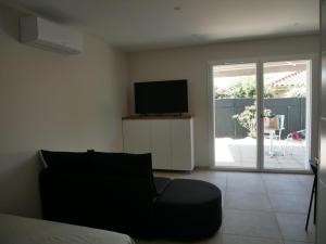 a living room with a couch and a television at Studios Saint Mau 4 in Saint-Maurice-de-Gourdans