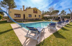 a pool with chairs and a slide in front of a house at Casa Bellavista con piscina en Caldes Costa Brava in Caldes de Malavella