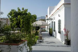 a walkway with a table and an umbrella on a building at Hotel Boutique Alcazaba Salobreña in Salobreña