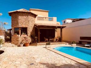 a villa with a swimming pool and a house at Villa Ingrid. Piscina exterior. in Las Playitas