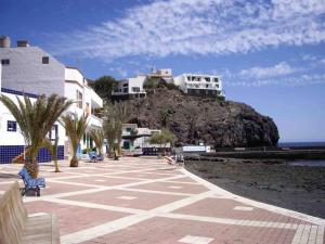 a building on top of a hill next to the beach at Villa Ingrid. Piscina exterior. in Las Playitas