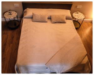 a large bed in a room with two side tables at Adapartament in Vercelli +4 photos