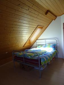 Bett in einem Zimmer mit Holzdecke in der Unterkunft Holiday Apartment Bombach in Kenzingen