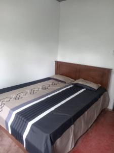 a bed with a wooden headboard in a room at Down Fattna Eco Villa in Deniyaya