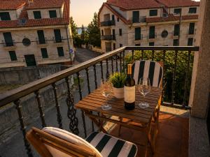 a table with two chairs and wine glasses on a balcony at Dunas de Corrubedo in Ribeira