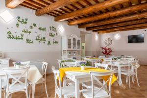 a dining room with white tables and white chairs at Villa Paradiso in Pioraco