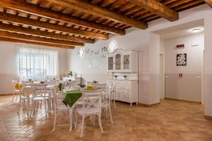 a kitchen and dining room with white tables and chairs at Villa Paradiso in Pioraco