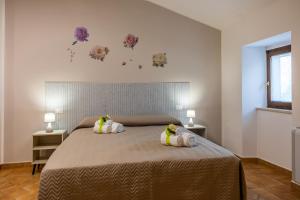 a bedroom with a bed with two stuffed animals on it at Villa Paradiso in Pioraco