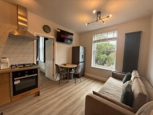 a living room with a couch and a kitchen at Castle Mount Apartments in Sandal and Walton