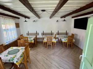 a dining room with tables and chairs and a tv at Casa Izvoarele in Izvoarele