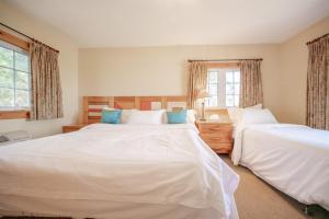 a bedroom with two white beds and two windows at Lakefront Cottage Private Beach & & Kayaks in Georgina