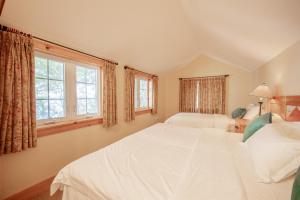 a bedroom with two beds and two windows at Lakefront Cottage Private Beach & & Kayaks in Georgina