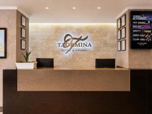a reception counter in a hotel with a sign on it at Taormina Hotel y Casino in San José