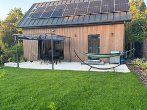 a house with a hammock and solar panels on it at Dom Okale in Kazimierz Dolny