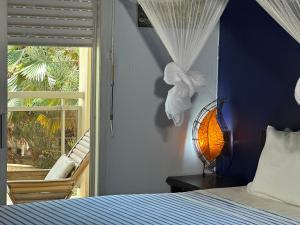 a bedroom with a bed and a window and a lamp at Villa malaka in Dakar