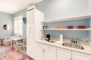a kitchen with a sink and a living room at Sunny Side Cottages in Dunedin