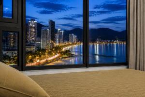 a room with a view of a city at night at Sea View Apartment Muong Thanh Oceanus Nha Trang in Nha Trang