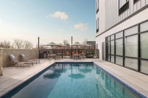 a swimming pool with tables and chairs next to a building at SpringHill Suites by Marriott Abilene in Abilene