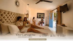 a man and a woman sitting on a bed at Casa Heredia Boutique in Cartagena de Indias