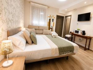 a bedroom with a large bed and a couch at El Mirador de Alcuneza in Sigüenza