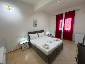a bedroom with a bed and a red window at Vila Olti in Vlorë