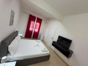 a small bedroom with a bed and a television at Vila Olti in Vlorë