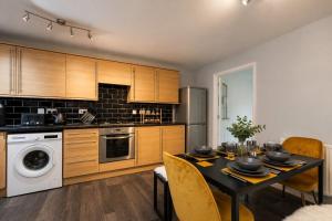 a kitchen with a table and a dining room at Large 3 bed Double Driveway Smart TVLong Stays in Durham +9 photos