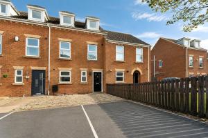 a brick house with a fence in front of it at Large 3 bed Double Driveway Smart TVLong Stays in Durham