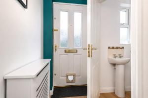 a bathroom with a white door and a sink at Large 3 bed Double Driveway Smart TVLong Stays in Durham