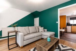 a living room with a couch and a green wall at Large 3 bed Double Driveway Smart TVLong Stays in Durham
