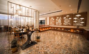 a dining room with a table and a chandelier at Hotel Le Amritam in Dehradun