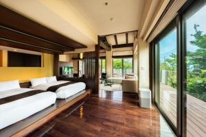 a bedroom with two beds and a balcony at Okuyado Buaiso in Yufu +74 photos