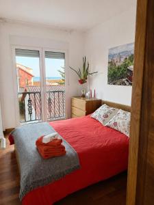 a bedroom with a red bed and a large window at Dunas de Corrubedo in Ribeira