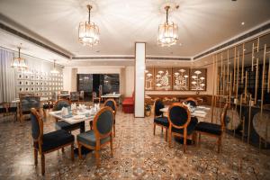 a dining room with tables and chairs and chandeliers at Hotel Le Amritam in Dehradun